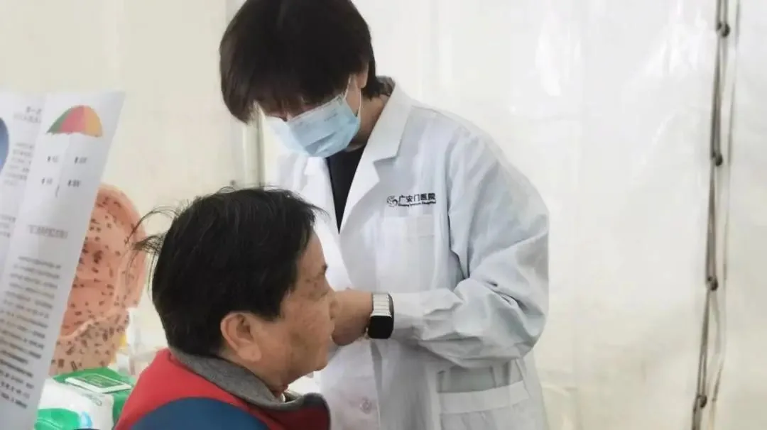 Hospital acupuncture nurse demonstrating auricular acupressure at a public health event; confirm an individual treatment with a clinician