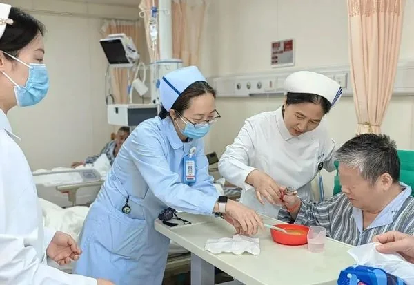 Huadong geriatric nursing team assisting a patient in an official Fudan University account