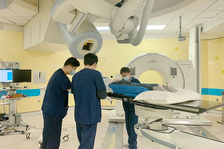 Hospital clinical team positioning a patient at the particle therapy machine